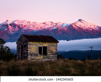 Rustic Tiny Home Abandoned On A Farm In Front Of A Snow Capped Mountain In Rural New Zealand