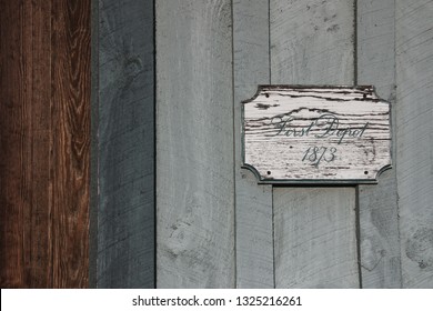 Rustic Train Depot Sign Against Weathered Wooden Planks In Brown, Blue, And Grey