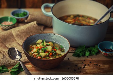 Rustic Veggie Loaded Soup On A Rust Wooden Background In A Clay Bowl.