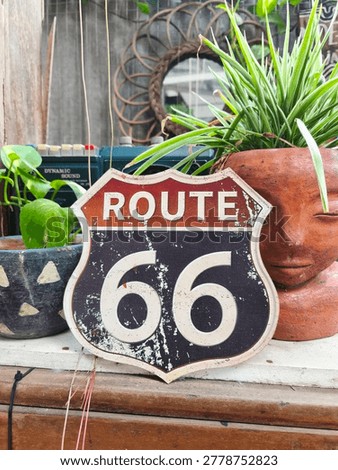 Rustic vintage decor featuring a Route 66 sign and a unique terracotta face planter with green grass