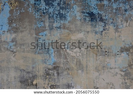 Rustic weathered concrete wall with layers of paint and plaster