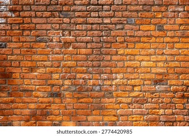 A rustic weathered red brick wall background featuring aged clay blocks with varied orange and crimson tones and rough mortar joints under bright natural sunlight.
This high-resolution photograph captures the timeless essence of a traditional masonry structure, showcasing a textured expanse of an old brickwork facade. The image reveals a rich tapestry of warm earthy hues, ranging from deep burnt sienna and terracotta to vibrant amber and pale ochre. Each individual brick displays its own unique character, marked by the passage of time through chipped edges, porous surfaces, and subtle variations in size. The historical aesthetic is further emphasized by the rugged mortar lines that weave between the rows, some deeply recessed while others are flush with the surface, creating a compelling rhythmic pattern.
The lighting plays a crucial role in this composition, casting soft shadows that accentuate the three-dimensional quality of the stone-like texture. Subtle remnants of past markings and natural weathering add an authentic urban or industrial feel to the scene, making it an ideal backdrop for architectural concepts, vintage themes, or rustic interior design projects. The horizontal alignment of the courses provides a sense of stability and craftsmanship, reflecting the enduring nature of classic construction methods. This versatile visual asset is perfect for designers looking for a high-quality organic texture that balances complexity with a clean, professional aesthetic. Whether used as a base for digital art or a stand-alone environmental detail, this weathered partition tells a story of durability and rustic charm.