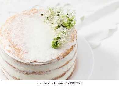 Rustic wedding cake with white lilac, light background, close up, selective focus