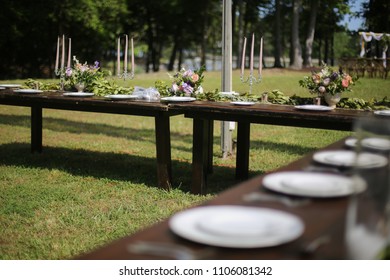 Rustic Wedding Decor Pink, Peach, Purple, And Green Floral Centerpieces On A Wooden Farm Table