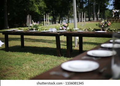 Rustic Wedding Decor Pink, Peach, Purple, And Green Floral Centerpieces On A Wooden Farm Table