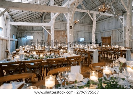 Rustic wedding dinner setup in a decorated barn