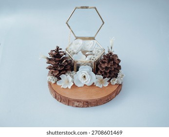 Rustic wedding ring box with flowers and pinecones on a wooden base. Elegant bridal detail