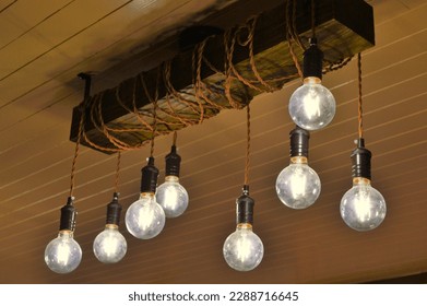 rustic wood block hanging old style light bulbs on an industrial western ceiling fixture - Powered by Shutterstock