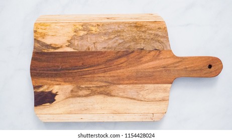 Rustic Wood Cutting Board On Marble Kitchen Counter.