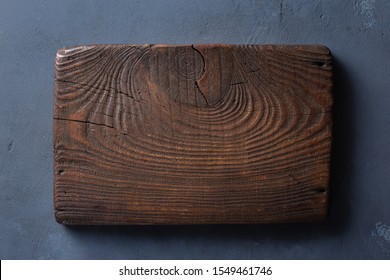 Rustic Wood Cutting Board On Dark Table Top View