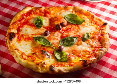 Rustic wood fired oven baked home made style real italian pizza shot in pizzeria