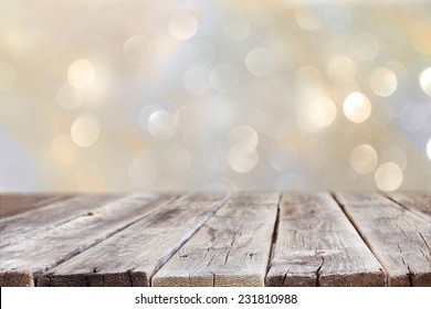 Rustic Wood Table In Front Of Glitter Silver And Gold Bright Bokeh Lights 