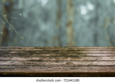 Rustic Wood Table In Front Of A Mystical Forest With Fog And Drop Of Rain.