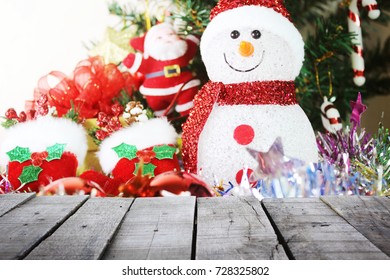 rustic wood table in soft focus of snowman,christmas tree background
