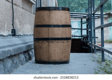 Rustic Wooden Barrel Against a Textured Stone Wall in an Urban Environment. - Powered by Shutterstock