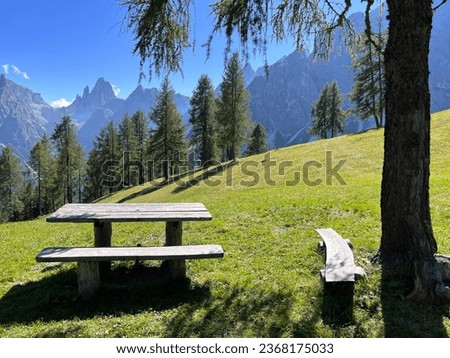 A rustic wooden bench with a gorgeous view of the Italian Alps, Dolomites
