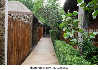 Rustic Wooden Bridge Walk Way Shaded And Silhouetted By Trees And Jungle Resort.