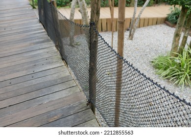 Rustic Wooden Bridge Walk Way Shaded And Silhouetted By Trees And Jungle Resort.