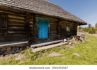 Rustic Wooden Cabin with Vibrant Blue Door Surrounded by Nature. - Powered by Shutterstock