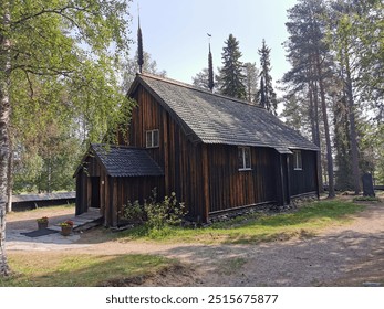 A rustic wooden church surrounded by tall trees. The sunlight filters through the branches, adding warmth to the quiet and serene natural setting. - Powered by Shutterstock