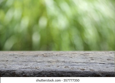 Rustic wooden counter top with blur bokeh garden background,  product display template