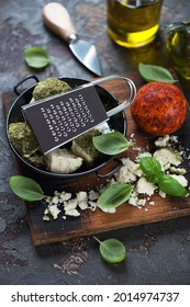 Rustic Wooden Cutting Board With Swiss Belper Knolle Cheese, Green Basil And Olive Oil, Vertical Shot, Selective Focus