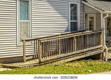 Rustic Wooden Handicap Ramp On Vintage House With Fabric Tacked Up Inside Windows And Metal Drainpipe On Porch - College Town