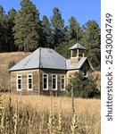 Rustic wooden one room school house with bell tower in scenic country setting