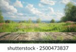 A rustic wooden plank tabletop placed over a blurred background of a vibrant green meadow with colorful wildflowers and a blue sky with white clouds.