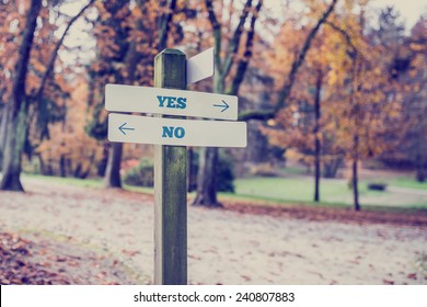 Rustic Wooden Sign In An Autumn Park With The Words Yes - No Offering A Choice Of Action And Attitude With Arrows Pointing In Opposite Directions In A Conceptual Image.