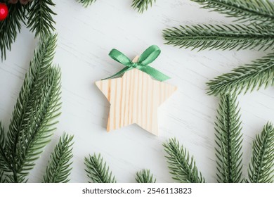 A rustic wooden star ornament with a green ribbon sits among fresh pine branches, creating a cozy, festive atmosphere perfect for holiday decorations. - Powered by Shutterstock