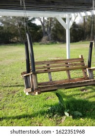 Rustic Wooden Swing Under A Rustic Pergola