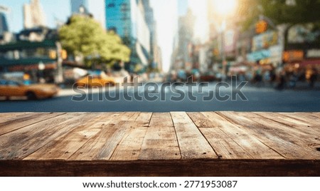 A rustic wooden table in the foreground with a blurred urban street scene in the background, featuring buildings, traffic, and pedestrians.