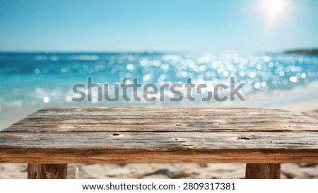 A rustic wooden table surface in the foreground with a blurred tropical beach and ocean background under a bright sunny sky.