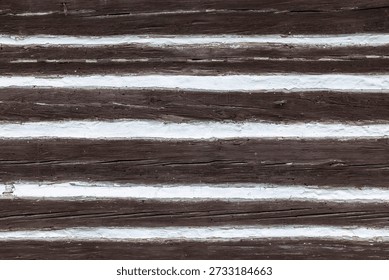 Rustic wooden wall texture showcasing brown logs and white chinking