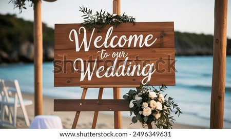 Rustic wooden wedding welcome sign with greenery and floral accents, displayed on an easel on a sandy beach with ocean in the background. Welcome to our wedding