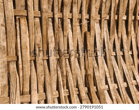 Rustic woven bamboo sheet backdrop. Rough organic wooden texture of traditional handmade wickerwork.