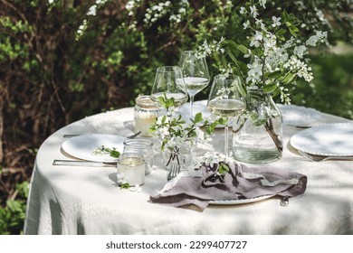 Rustic zero waste wedding decor with natural elements. Fresh spring blooming flowers, candles, linen napkins, wine glasses. Eco friendly decoration for the special holiday dinner. Romantic cozy place - Powered by Shutterstock