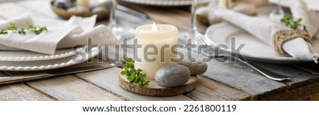Rustic zero waste wedding decor with natural elements. Wooden table, candles, linen napkins, branches with green leaves. Eco-friendly decoration for the special dinner. Romantic and cozy place. Banner