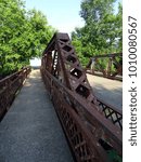 The rusting arch of a road  bridge over a small river in Coldwater, Michigan, USA