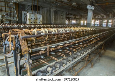 Rusting equipment on factory floor of abandoned turn of the century silk throwing factory.