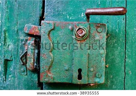 Rusting lock on an old door with paint peeling