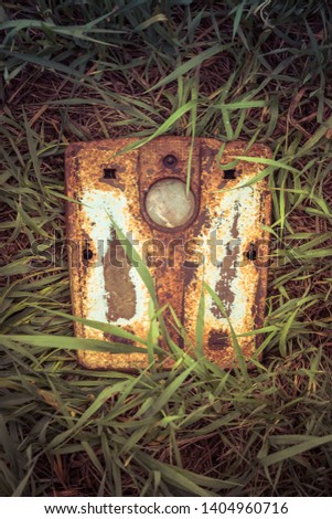 A rusty abandoned bathroom scale found in a field.
