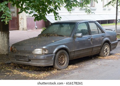 Rusty abandoned car on a city street - Shutterstock ID 616178261