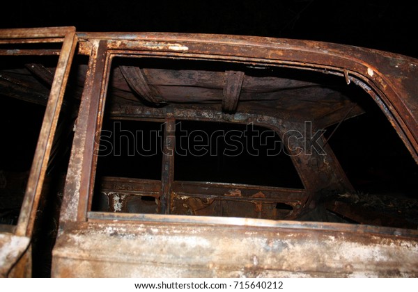 Rusty auto body on a black\
backgrond