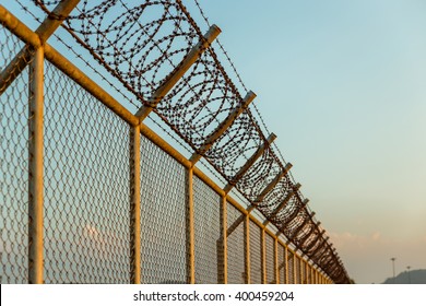 rusty barbed wire fence in sunny day - Powered by Shutterstock