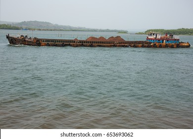 Rusty barge transporting iron ore on the Mandovi River