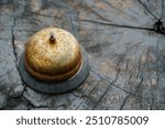 the rusty bell on the wooden table with dramatic tone