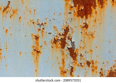 A rusty blue metal wall with fallen paint, a rusty background.