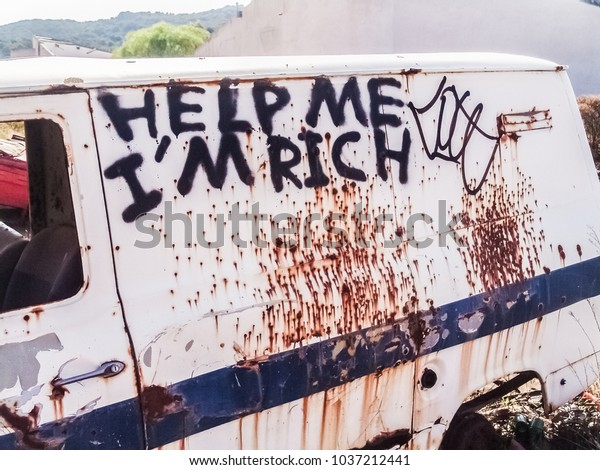 Rusty body\
car with the graffiti Help me I\'m\
Rich